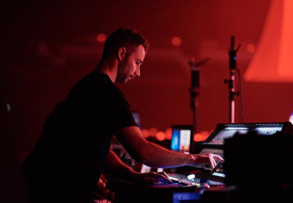 A Multi technician mixing at front of house under red stage light